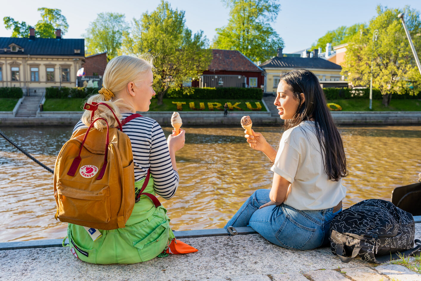 Students sitting with ice cream on the Turku riverbank