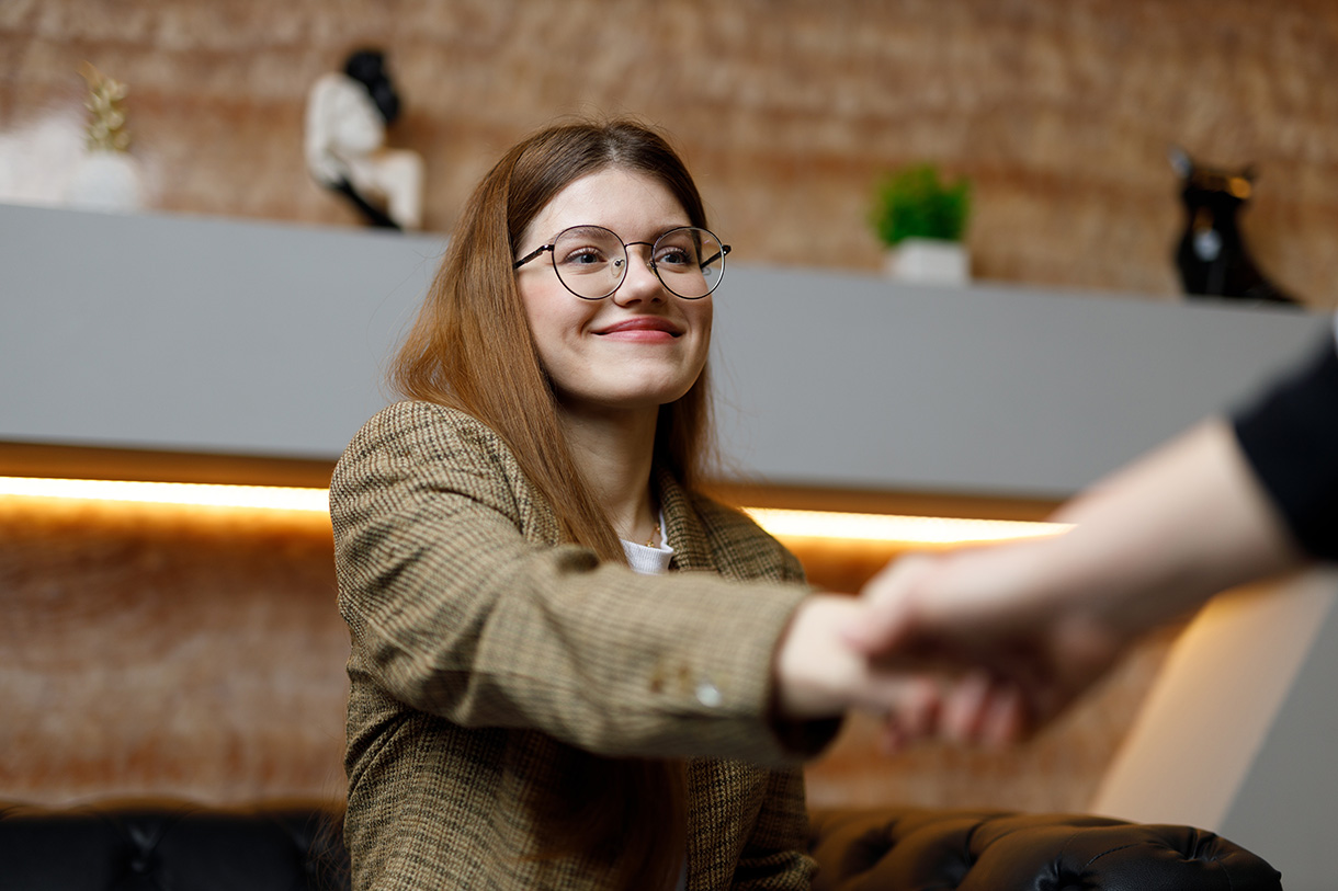 Henkilö kättelee toista toimistotilassa