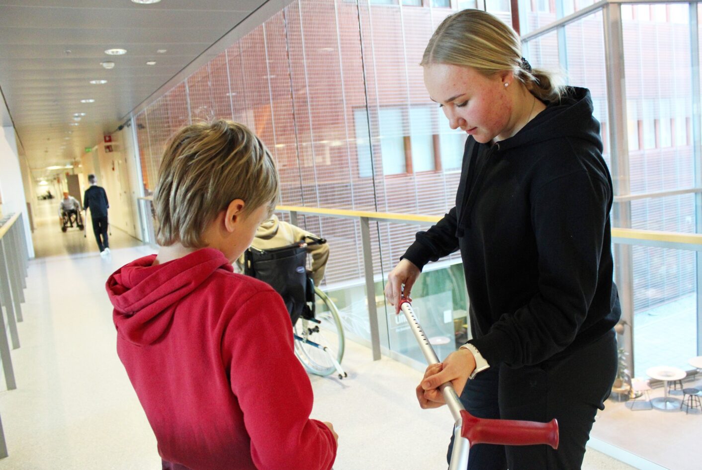 Fysioterpeuttiopiskelija esittelee apuvälinettä viidesluokkalaiselle.