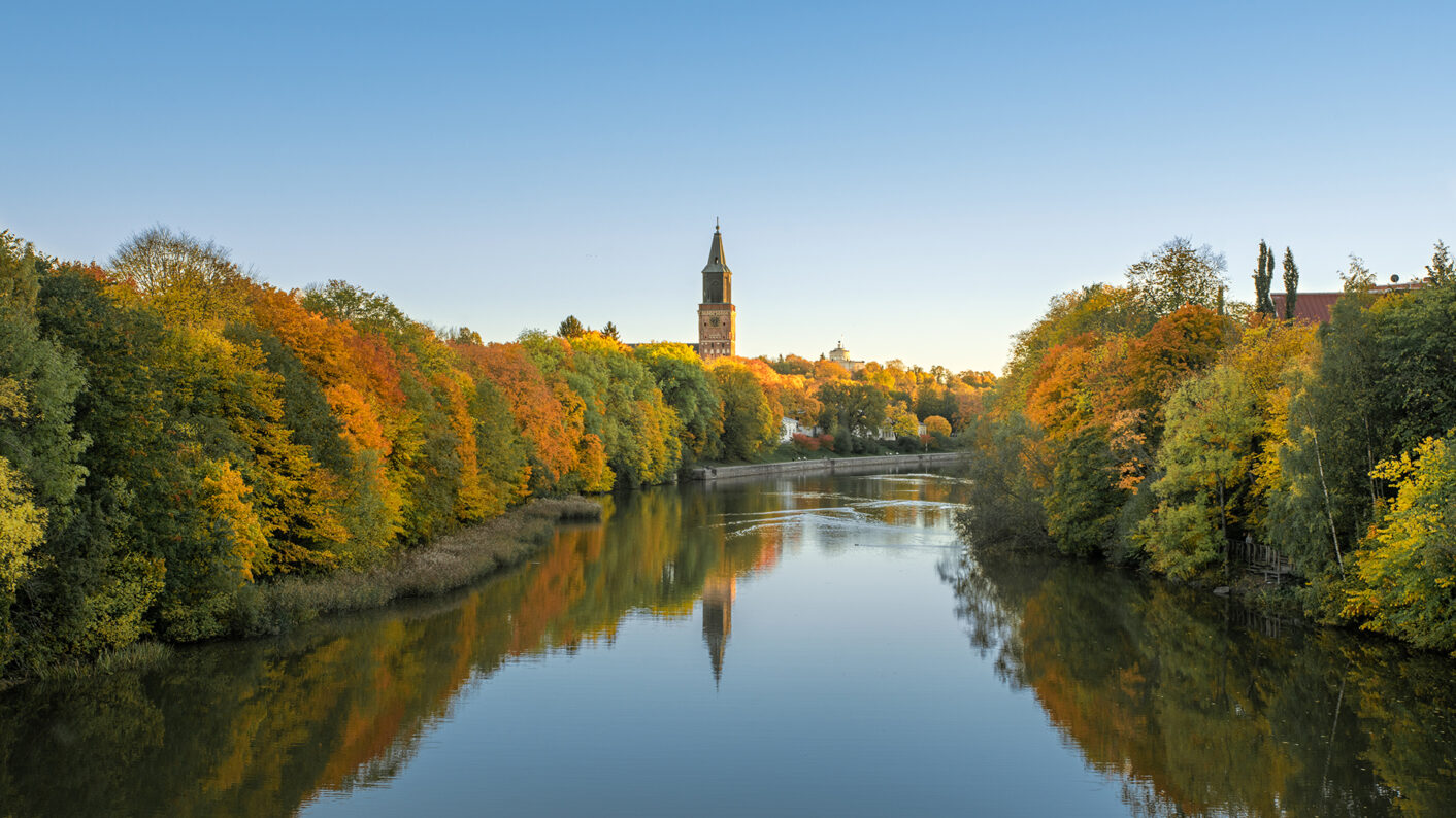 Aura river in autumn colors, Turku cathedral visible in the horizon.