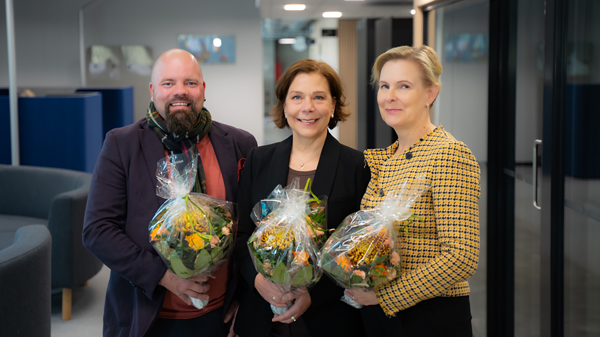 Kolme uutta Turun AMK:n koulutusjohtajaa Tero Reunanen (vas)., Anne Norström ja Jaana Kallio-Gerlander poseeraavat kukkapuskat käsissään.