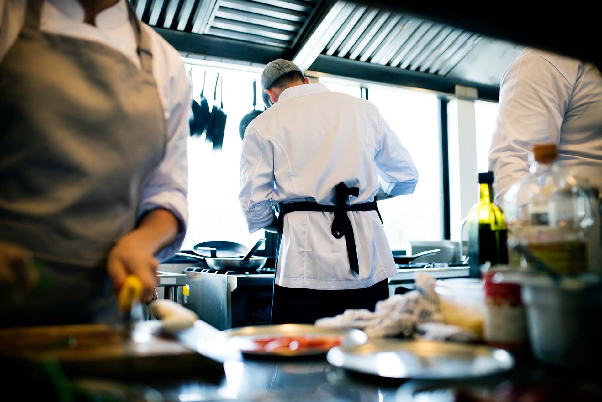 Restaurant kitchen, three people preparing food